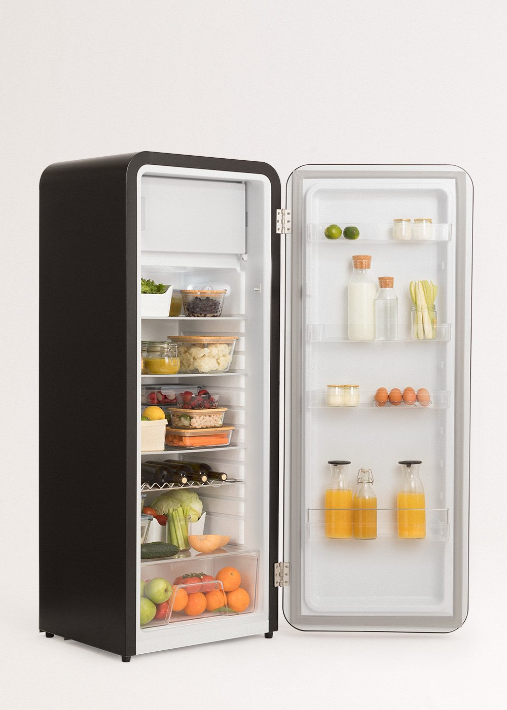 Un refrigerador negro abierto revela alimentos como verduras, frutas, huevos y bebidas. El refrigerador está bien organizado e iluminado.