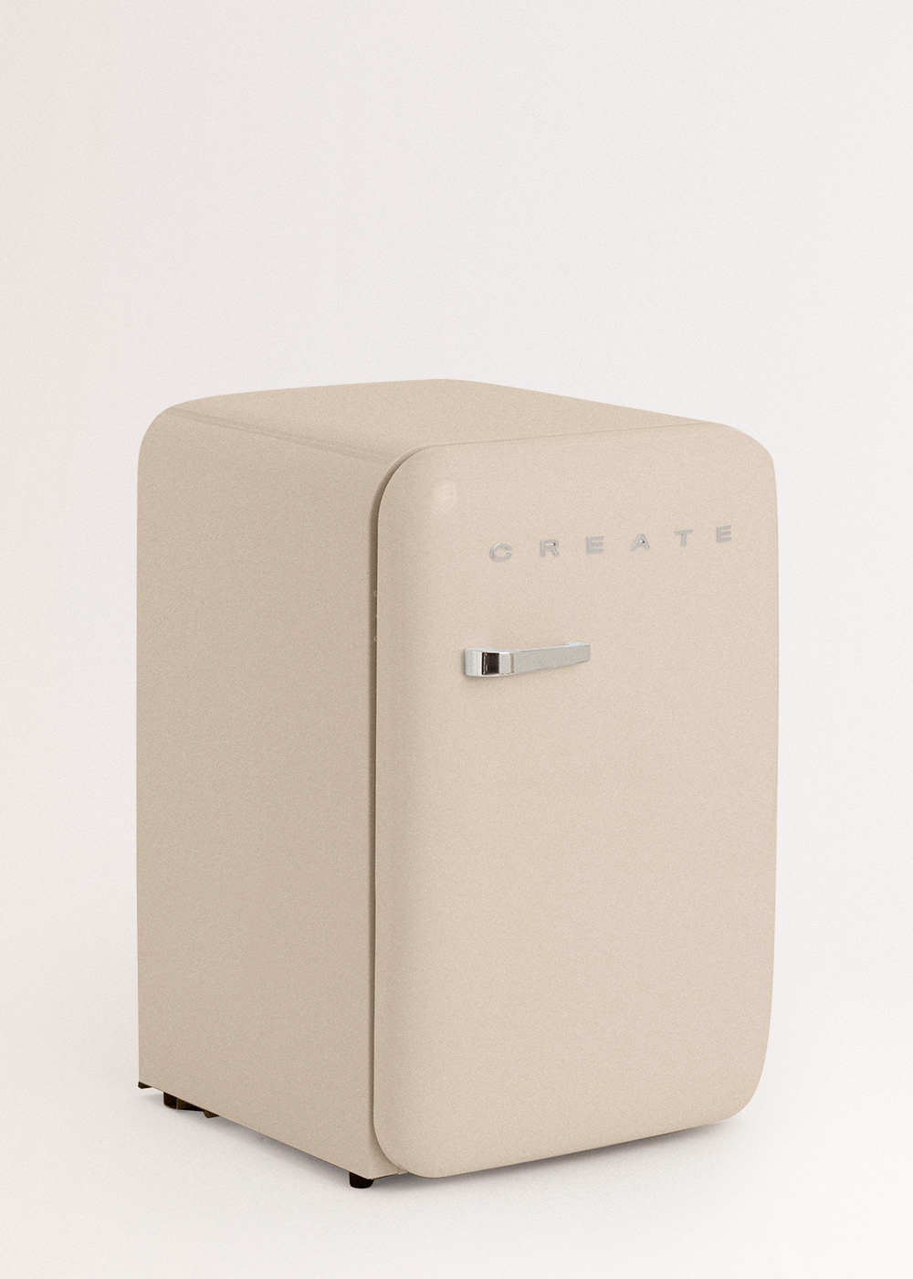 Un mini-refrigerador beige con la palabra CREATE en la parte delantera. Tiene un asa plateada y está sobre un fondo blanco.