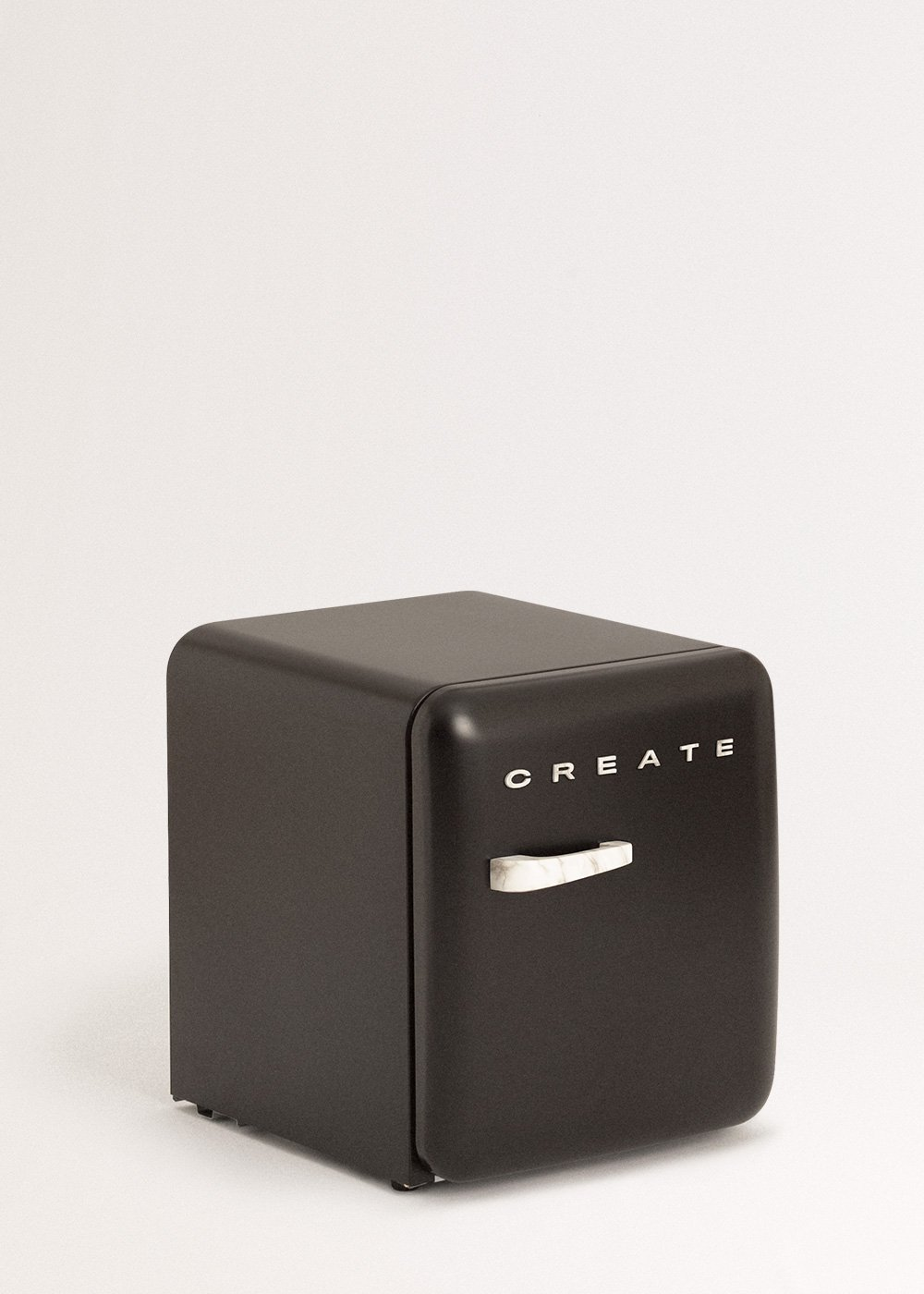Un pequeño refrigerador negro con un asa blanca y la palabra 'CREATE' en la puerta, sobre un fondo blanco.