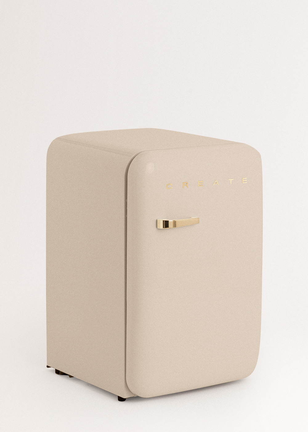 Un mini-refrigerador beige con manija y letras doradas CREATE. Está sobre un fondo blanco.