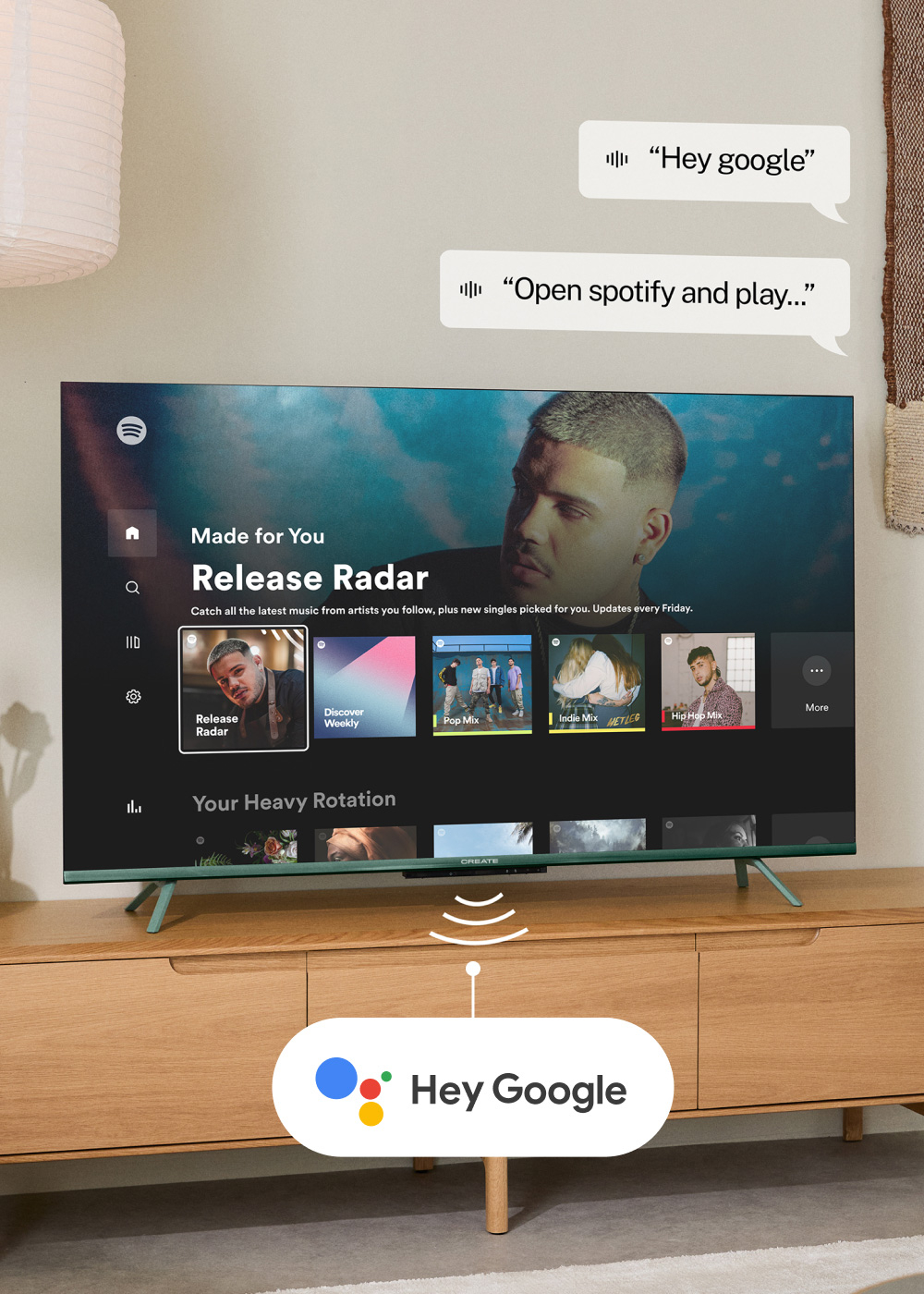 Un televisor muestra Spotify, controlado por comandos de voz. Un mueble de madera sostiene el televisor, con "Hey Google" debajo.
