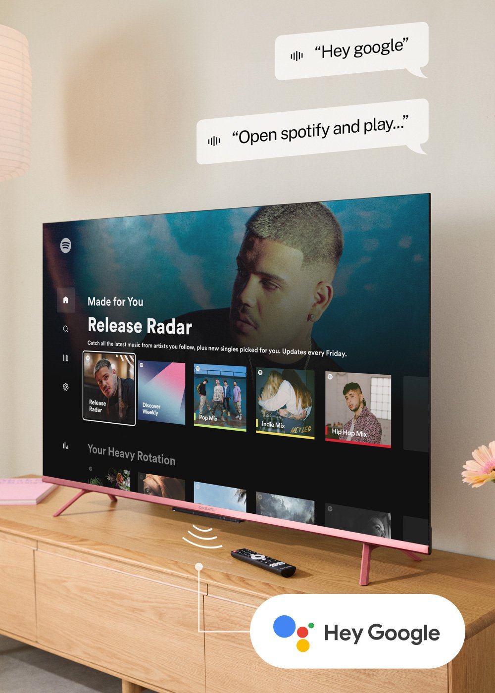 Un televisor muestra Spotify. Muestra la cara de un hombre y sugerencias de canciones. "Hey Google" y un mando a distancia están delante.