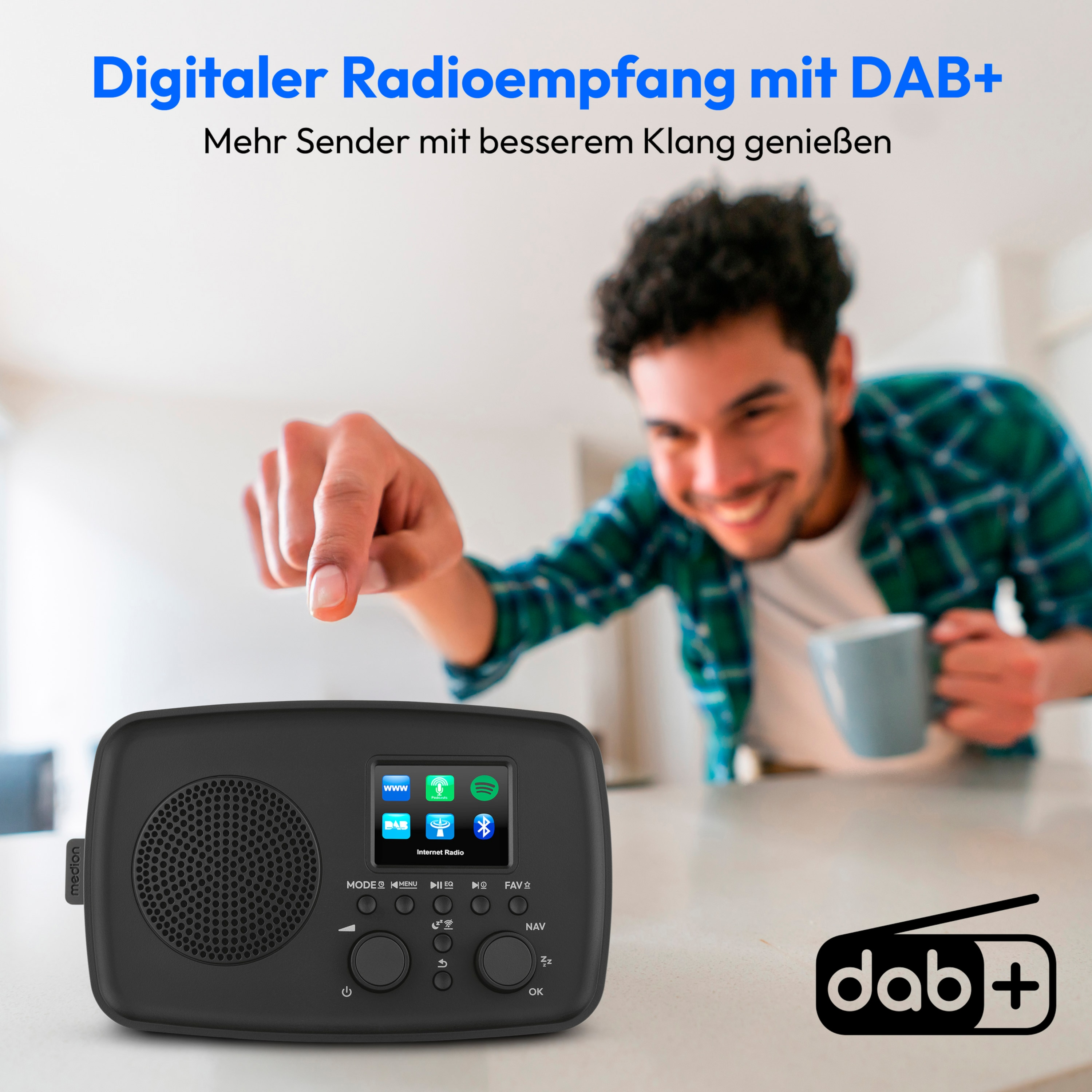 Mann zeigt auf ein schwarzes Radio. Ein Mann lächelt und hält einen Becher. Das Radio hat einen Bildschirm mit Symbolen.
