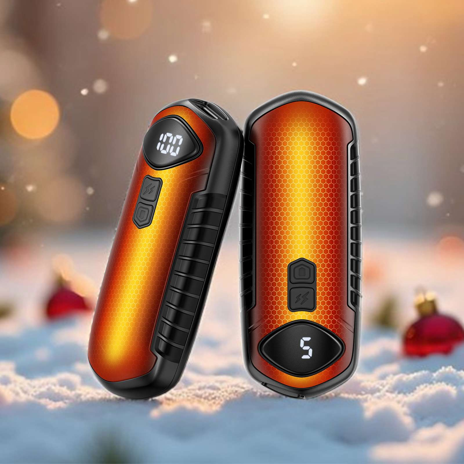 Zwei orange-schwarze Geräte mit Displays. Schnee und verschwommener Hintergrund mit Weihnachtsschmuck.