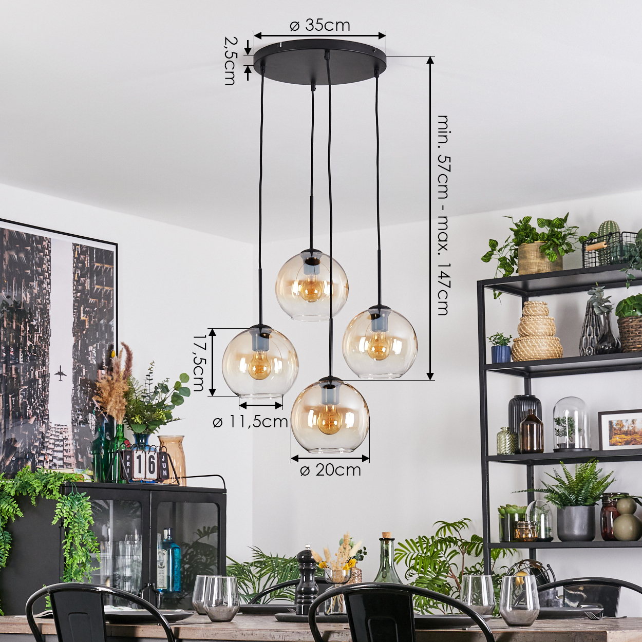 Ein Esszimmer mit einem schwarzen Kronleuchter mit vier Glaskugelleuchten. Ein Tisch ist mit Gläsern und Dekor gedeckt. Pflanzen sind sichtbar.