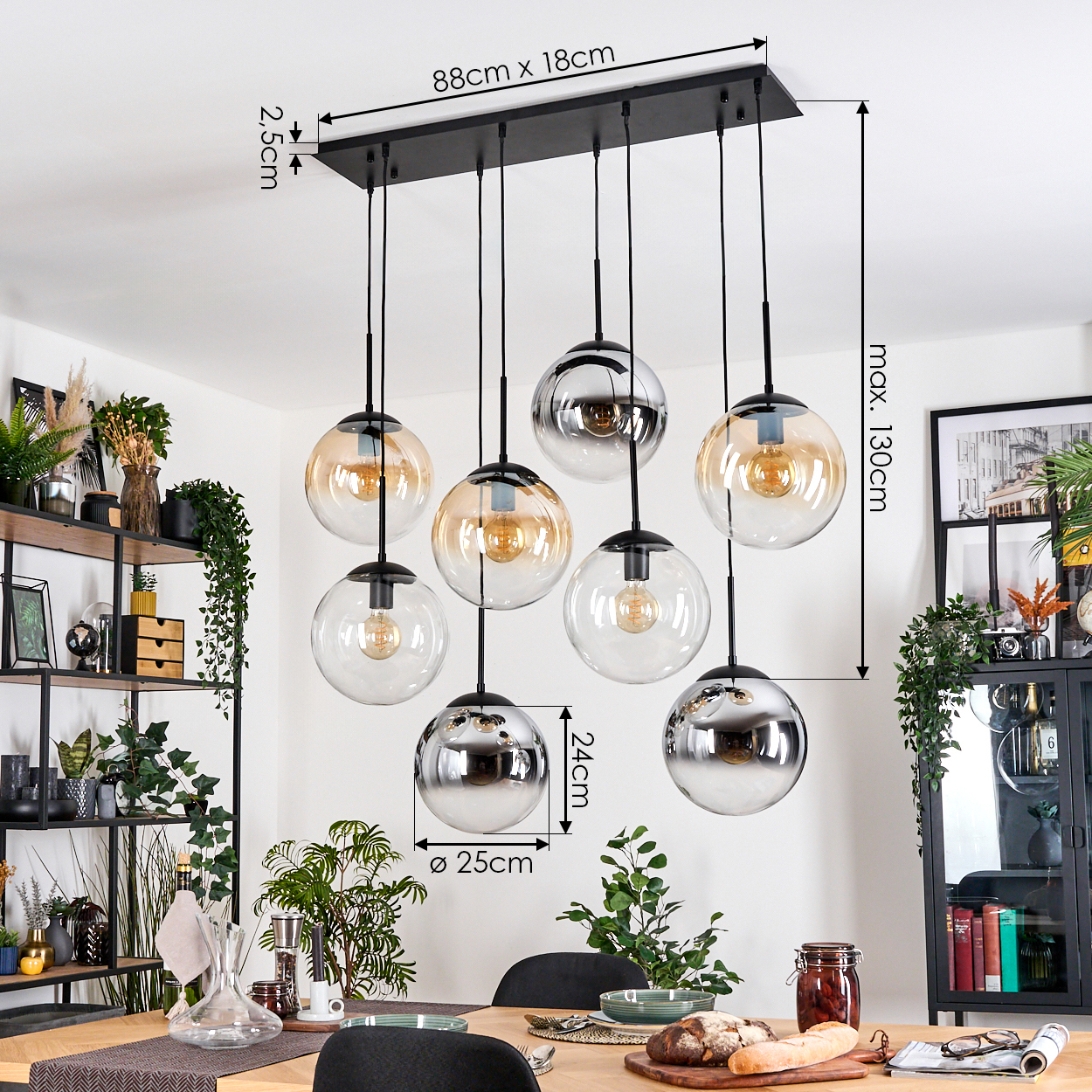 Eine moderne Hängelampe mit acht Glaskugeln hängt über einem Holztisch. Abmessungen sind angegeben. Pflanzen und Dekoration umgeben sie.