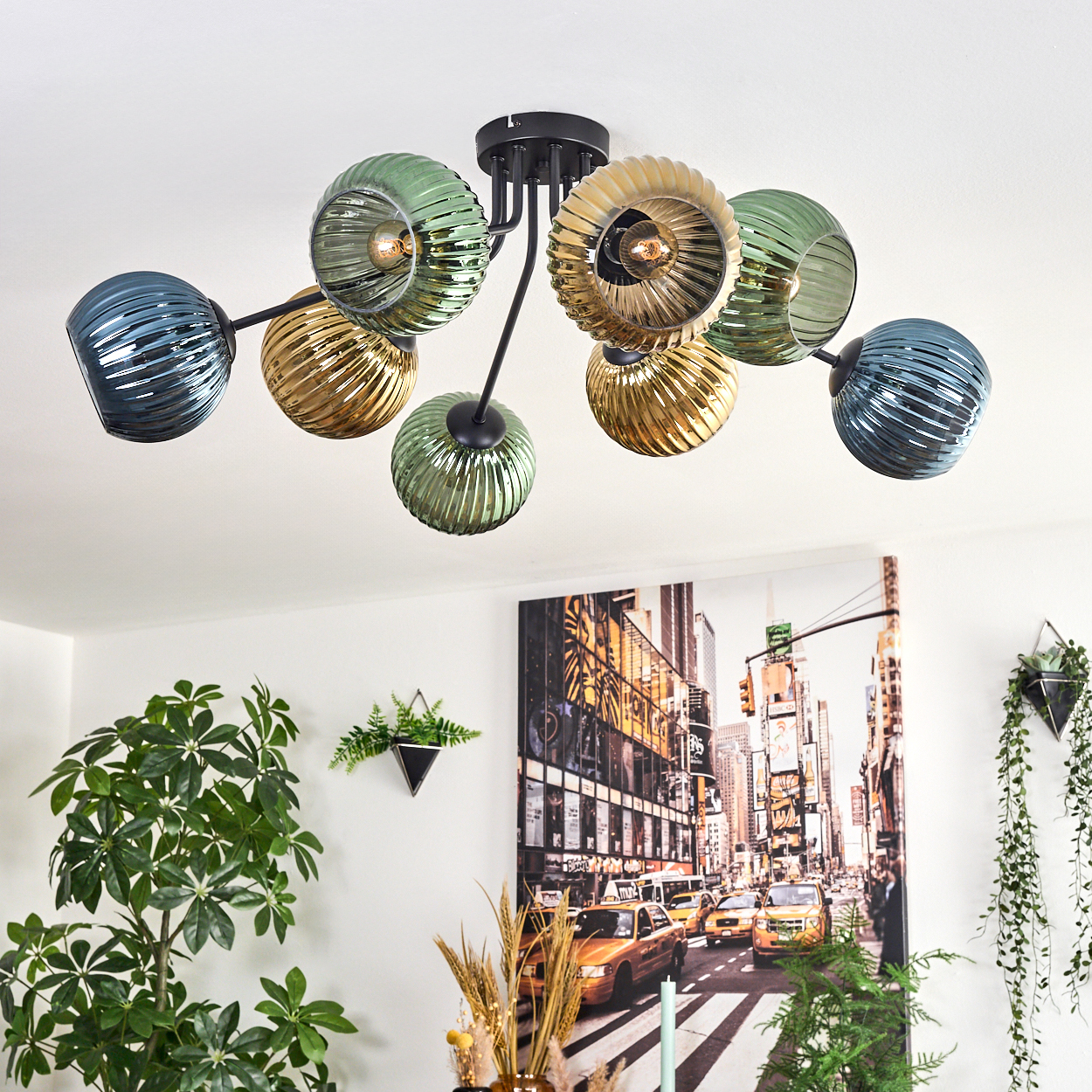 Deckenlampe mit blauen, goldenen und grünen Glaskugeln. NYC-Straßenkunst-Druck und Pflanzen im Hintergrund.