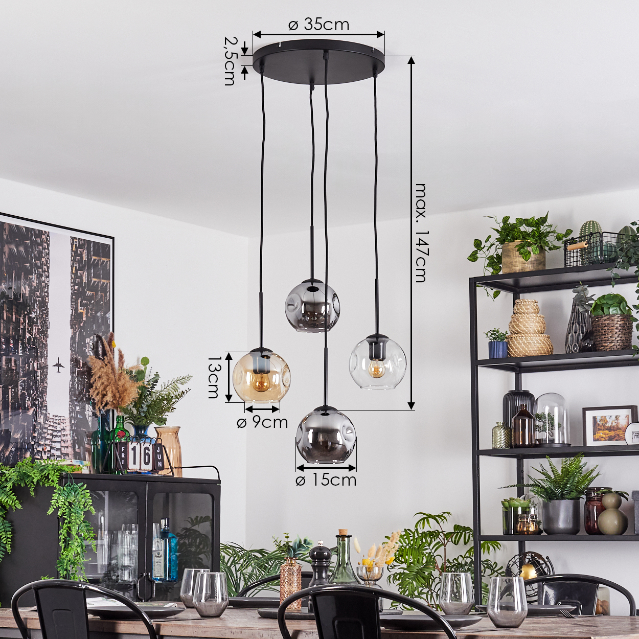 Ein Esszimmer mit einem schwarzen Kronleuchter mit drei Glaskugeln, Pflanzen und einem schwarzen Metallregal mit Dekorationen.