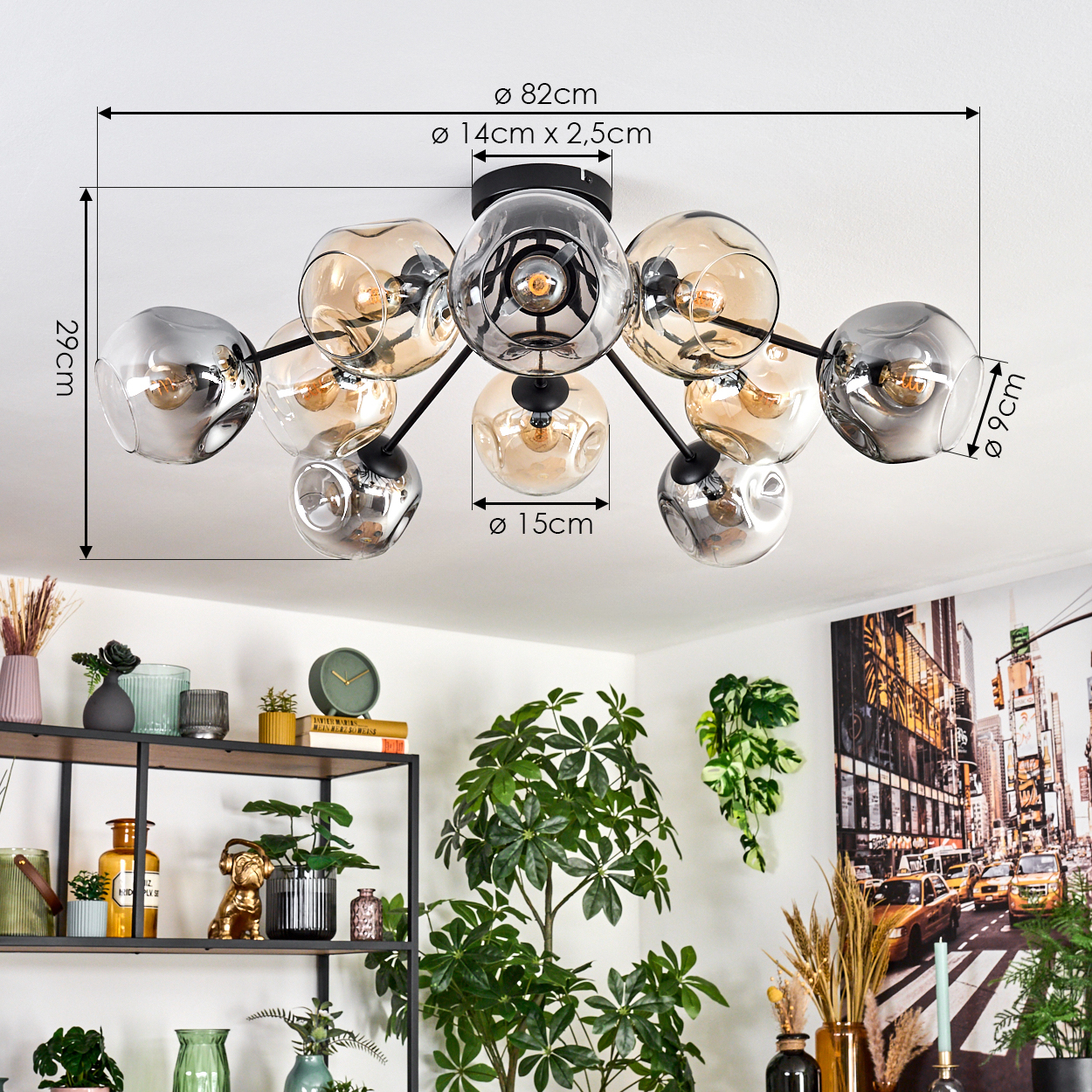 Eine moderne Deckenlampe mit Glaskugeln, Maße beschriftet. Darunter ein Regal mit Dekoration und Pflanzen, mit einem Stadtbild.