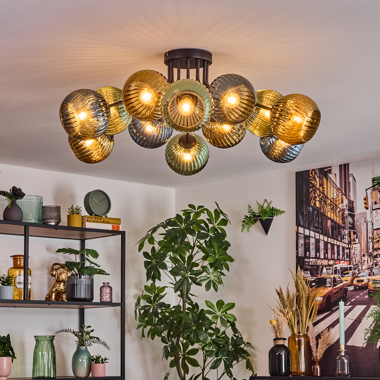 Ein modernes Wohnzimmer mit großem Kronleuchter. Regale mit Deko und Pflanzen im Vordergrund, mit einem Stadtbild im Hintergrund.
