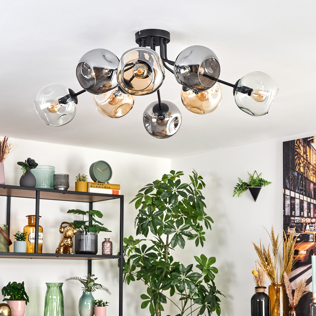 Eine moderne Deckenlampe mit Glaskugeln, Pflanzen und einem Regal mit Dekorationen. Im Hintergrund ist ein Straßenbild zu sehen.