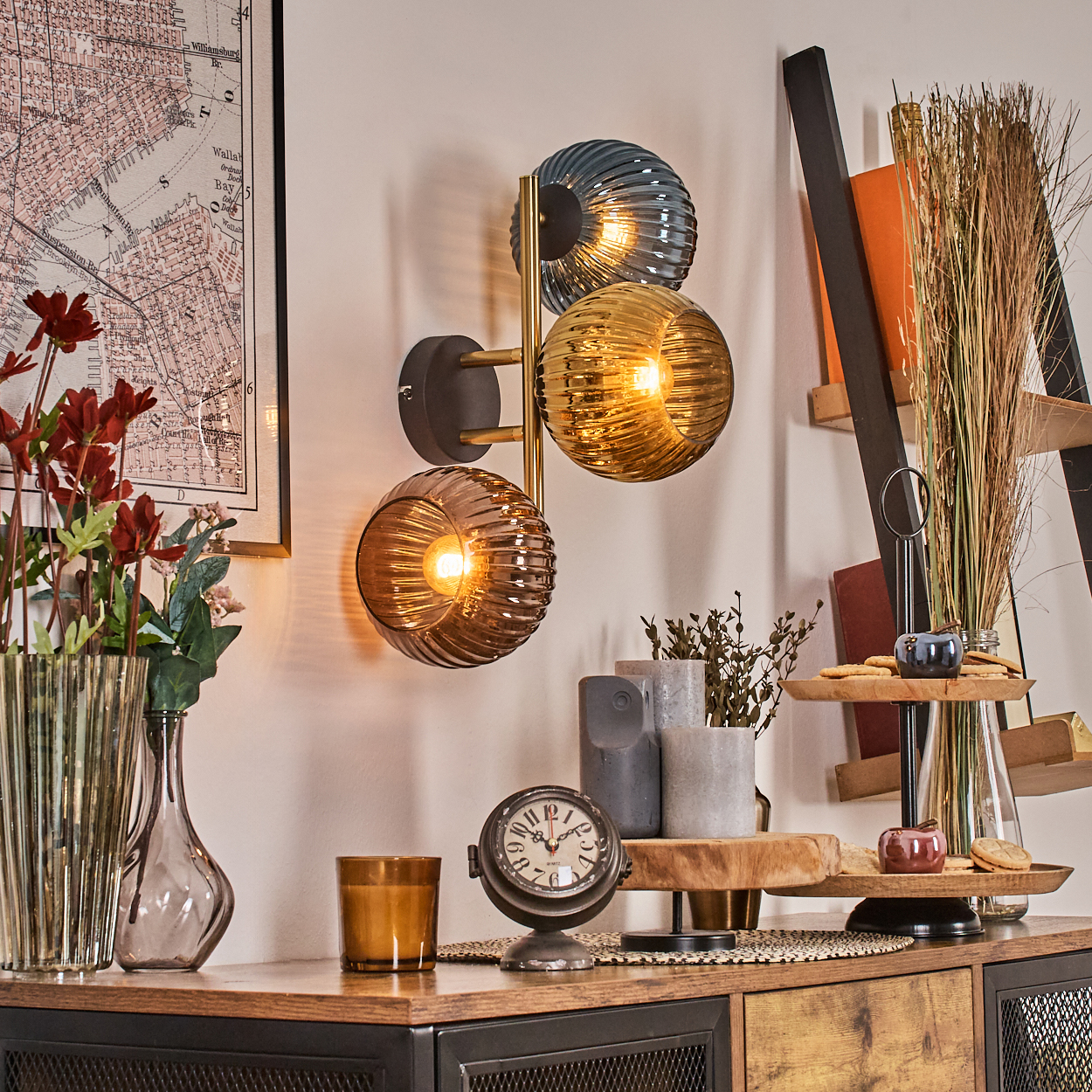 Ein Raum mit Lampe, Blumen, Uhr und Dekorationsartikeln auf einem Holzschrank, einer Karte an der Wand und einer Leiter.