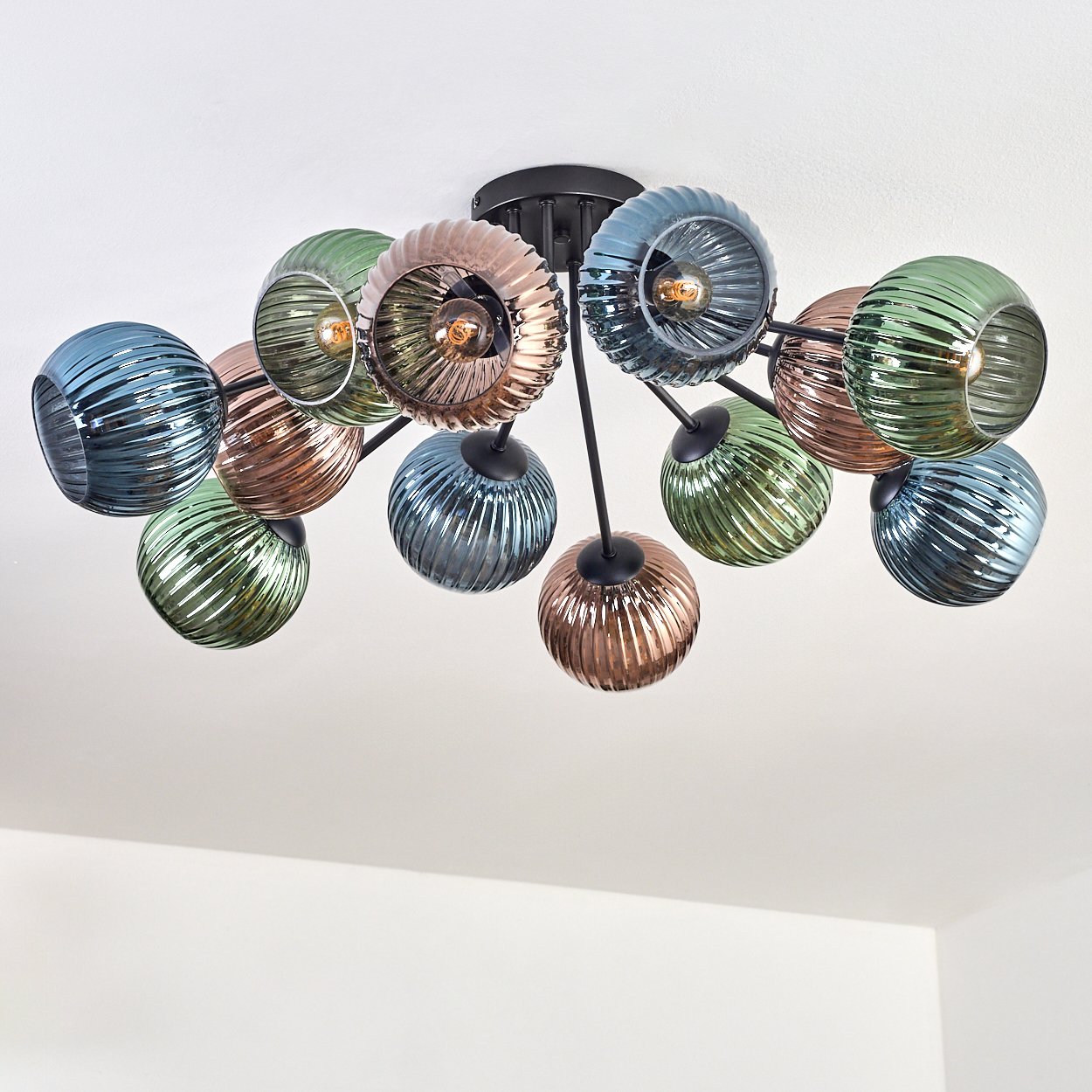 Eine moderne Deckenleuchte mit bunten Glaskugeln. Die Farben sind Blau, Grün und Bronze, vor einem weißen Hintergrund.