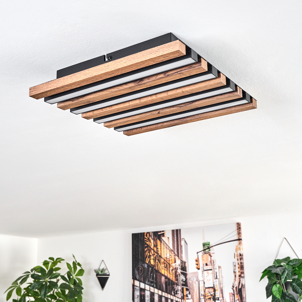 Holzdeckenlampe mit integrierten Lichtern. Darunter ein Stadtbild und Pflanzen. Die Lampe ist der Hauptfokus.