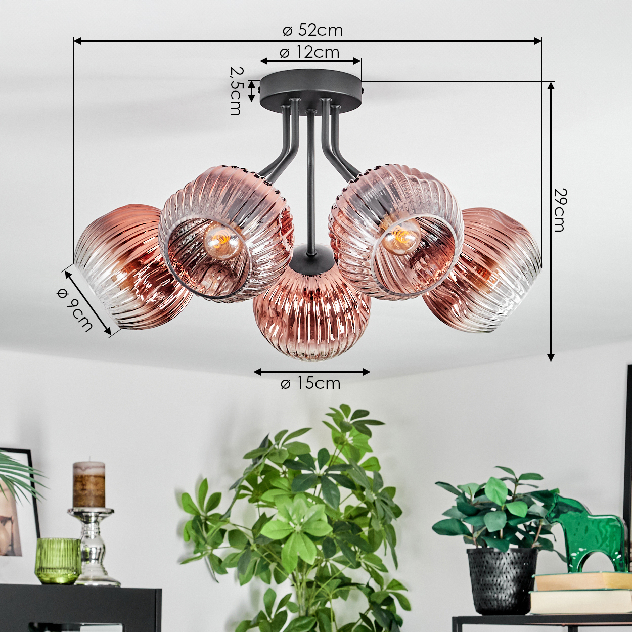 Deckenleuchte mit 5 rosa Glasschirmen. Maße sind angegeben. Pflanzen und Dekoration im Vordergrund.