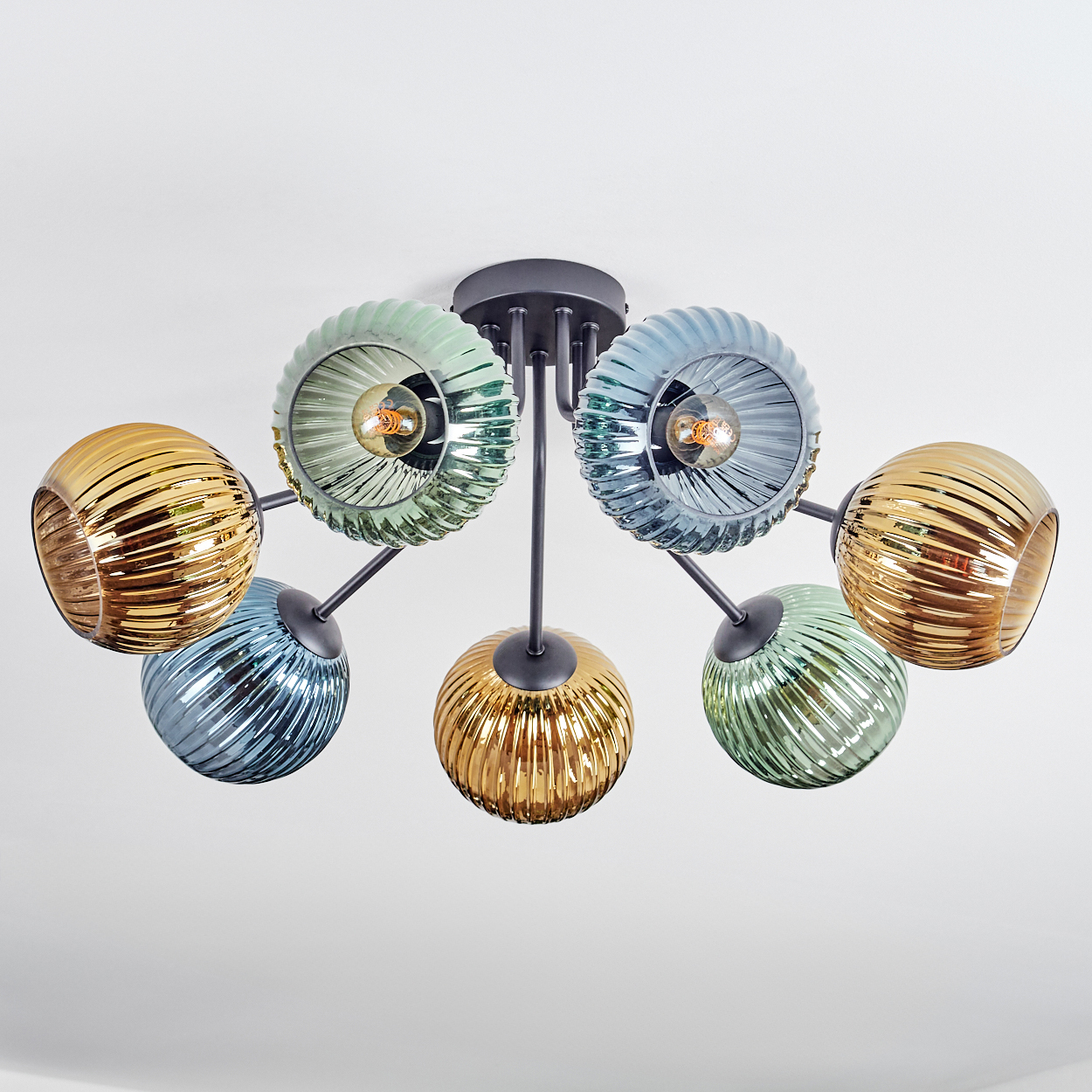 Eine moderne Deckenleuchte mit sechs Glaskugeln in verschiedenen Farben: Gold, Blau und Grün. Die Leuchte hat schwarze Metallarme und einen Sockel.
