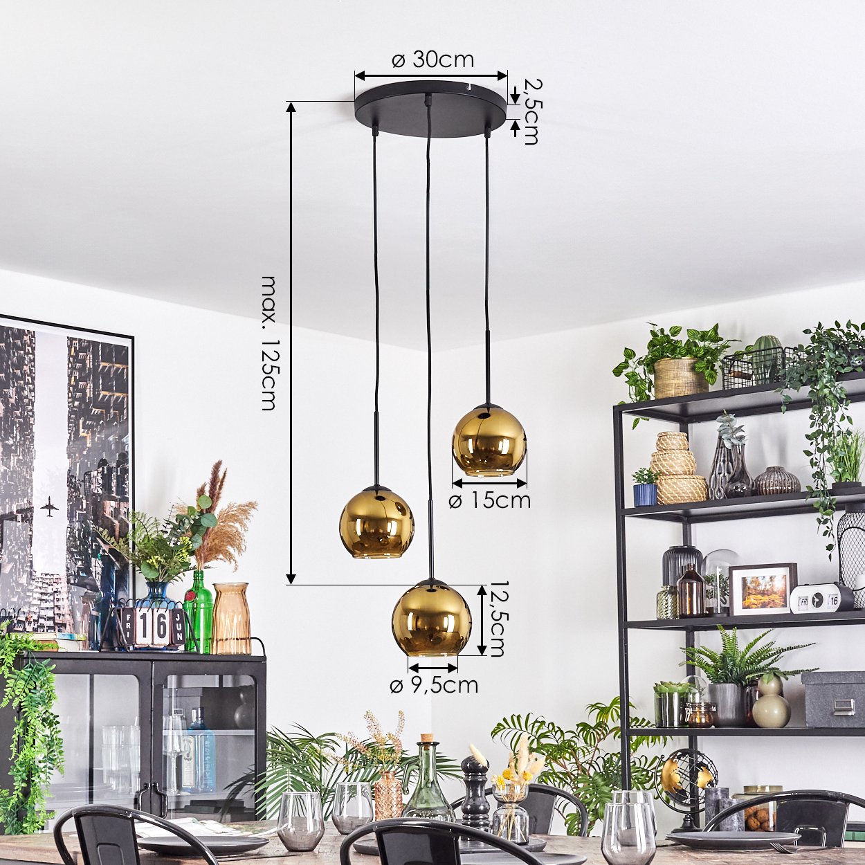 Drei goldene Pendelleuchten hängen von einer schwarzen Deckenplatte. Maße sind markiert. Darunter ist ein Esstisch mit einem Regal mit Pflanzen.