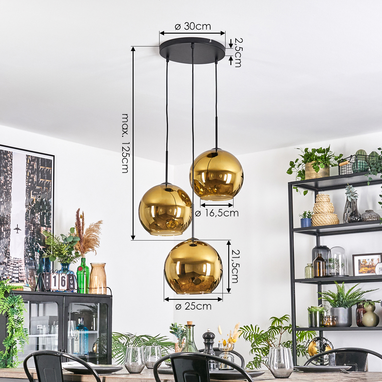 Drei goldene Hängelampen hängen über einem Esstisch. Abmessungen sind angegeben. Pflanzen und Dekorationen füllen den Hintergrund. Modernes Interieur.