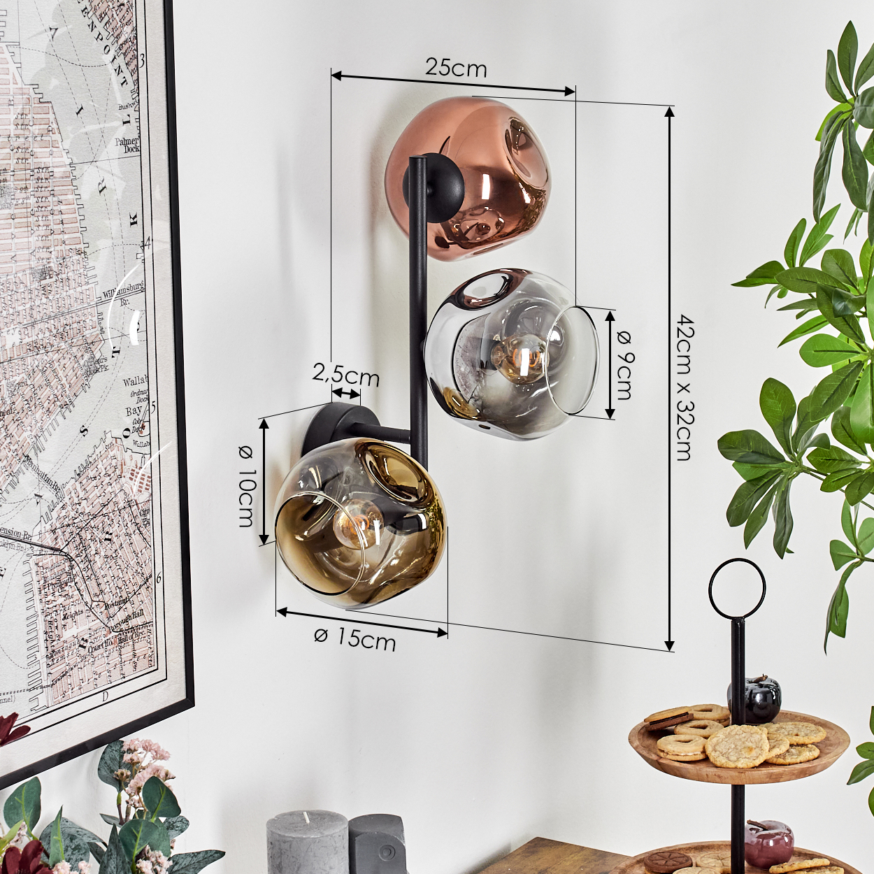 Eine moderne Wandlampe mit drei kugelförmigen Glasschirmen in verschiedenen Farben, montiert auf einem schwarzen Metallrahmen.
