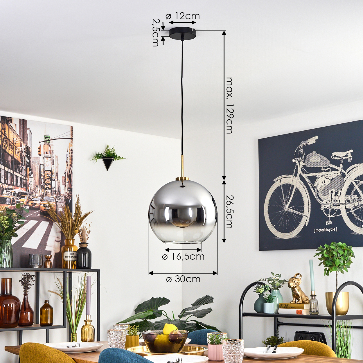 Ein modernes Esszimmer mit einer kugelförmigen Pendelleuchte und einem Tisch, der für eine Mahlzeit gedeckt ist. Kunstwerke und Dekoration sind sichtbar.