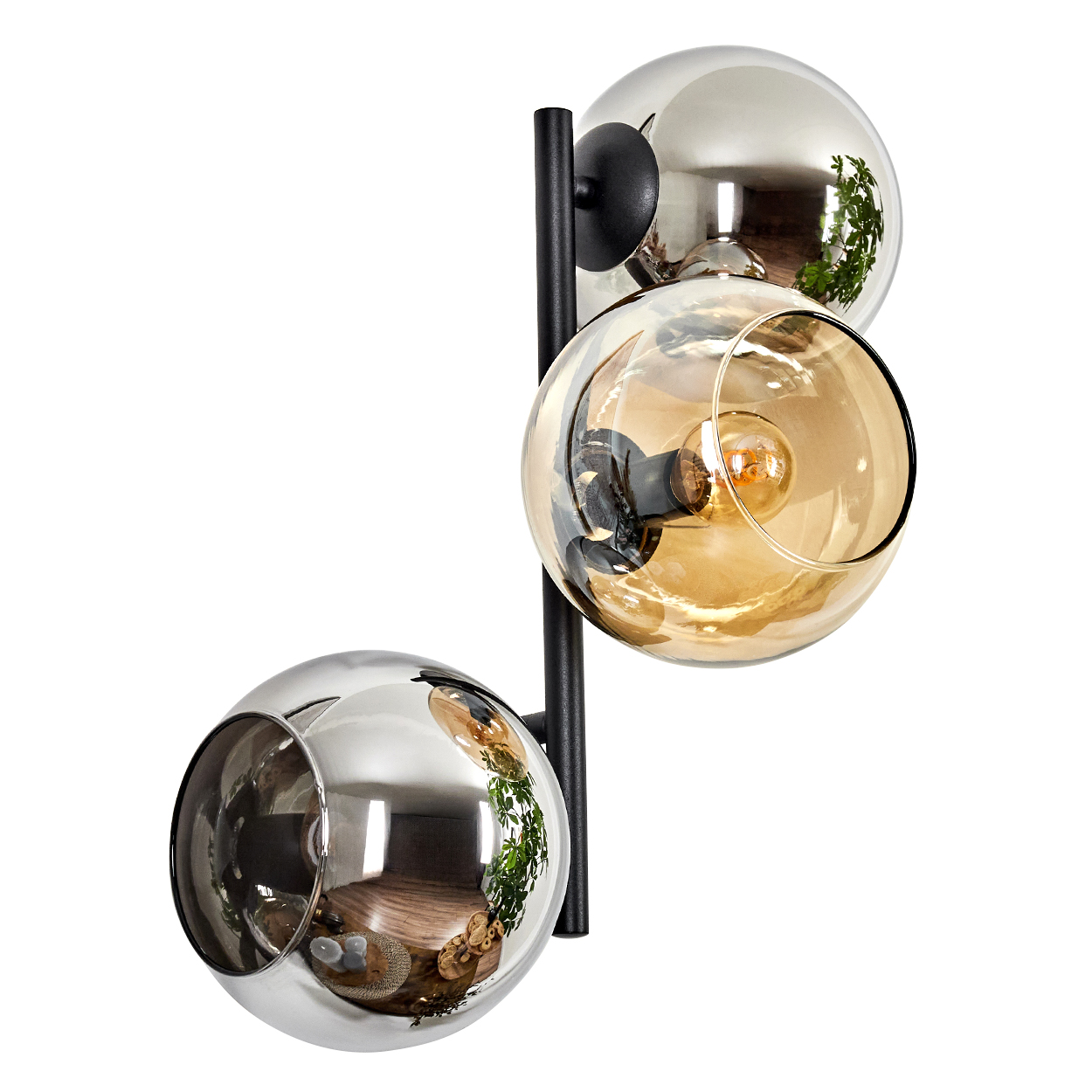 Eine moderne Lampe mit drei kugelförmigen Glasschirmen. Zwei sind verspiegelt, einer ist bernsteinfarben. Die Halterung ist schwarz, auf weißem Hintergrund.