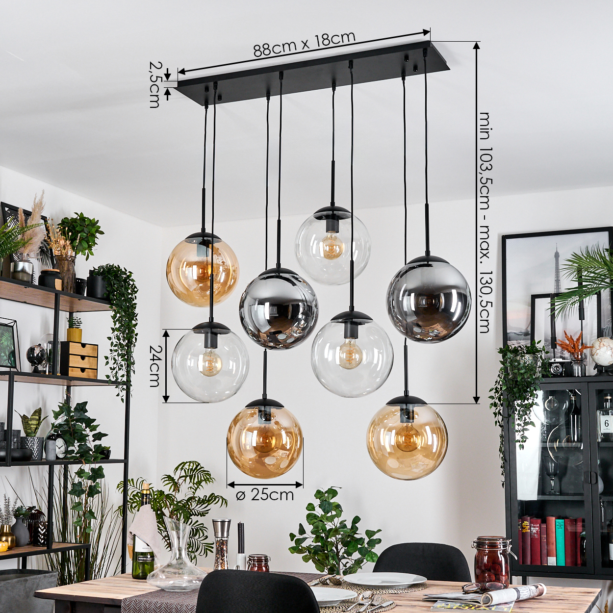 Eine moderne Hängelampe mit sechs Kugelleuchten hängt über einem Tisch. Abmessungen sind beschriftet. Pflanzen und Dekorationen sind im Hintergrund.