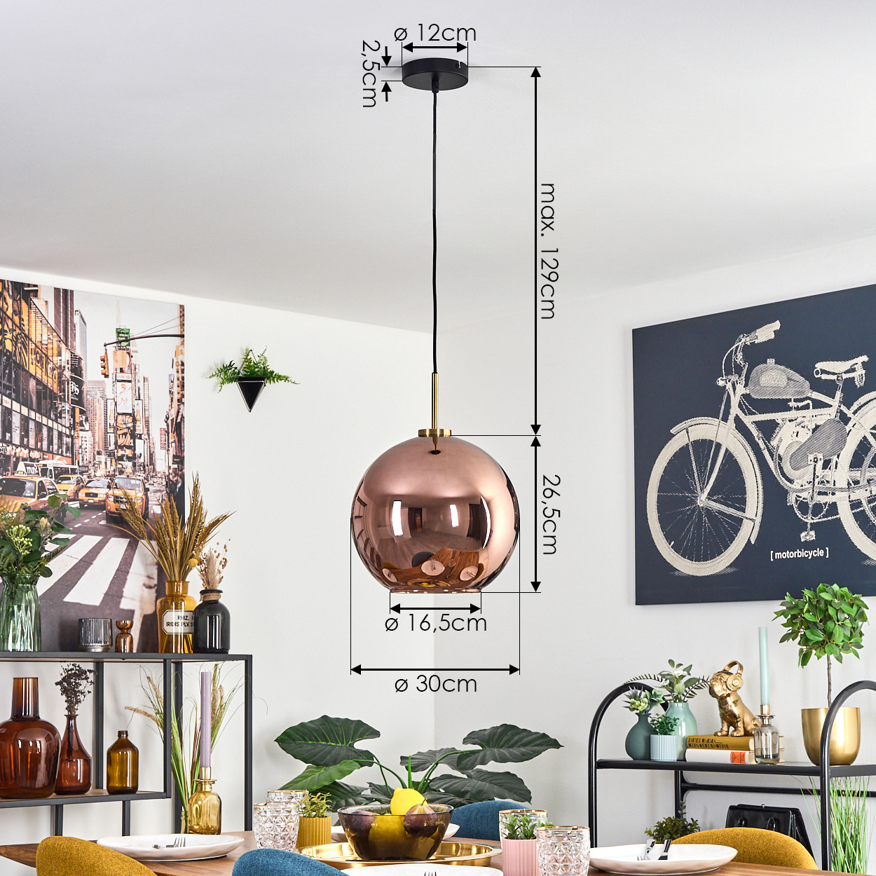 Eine kupferfarbene Kugelhängeleuchte hängt über einem Tisch. Das Bild zeigt die Abmessungen der Lampe und die Einrichtung des Raumes.