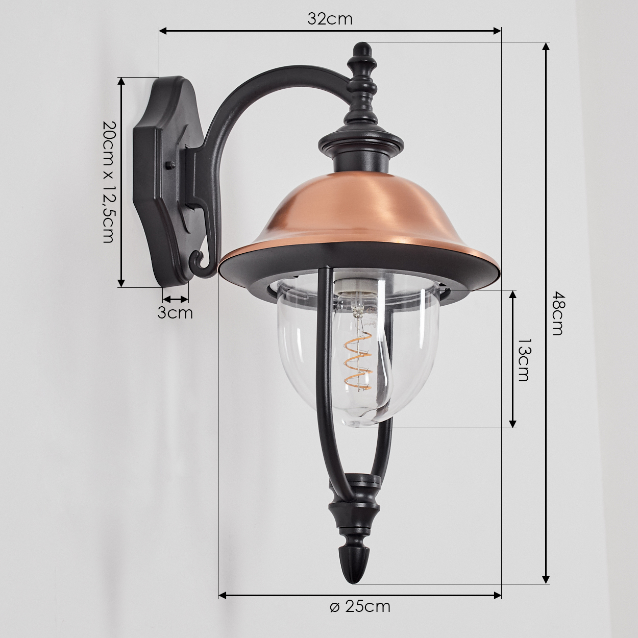Schwarze und kupferfarbene Außenlampe. Sie ist an einer Wand befestigt. Abmessungen sind angegeben.