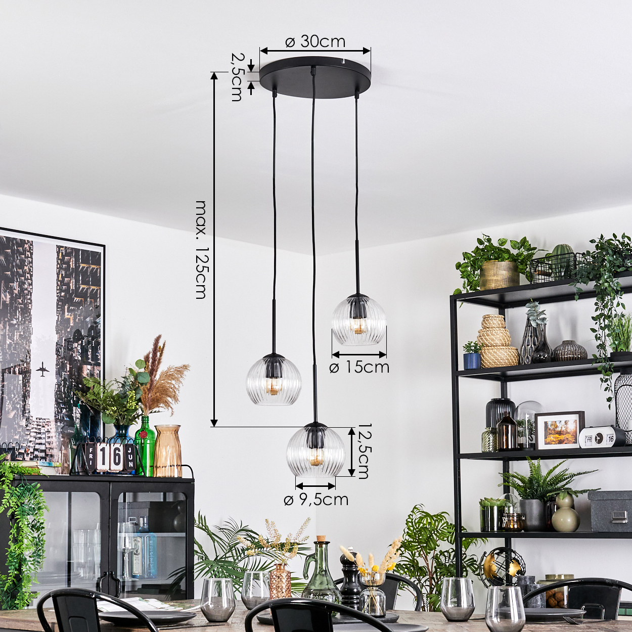 Ein Esszimmer mit hängenden Glaslampen. Schwarze Metallregale und Schrank mit Pflanzen und Dekorationen. Tisch zum Essen gedeckt.