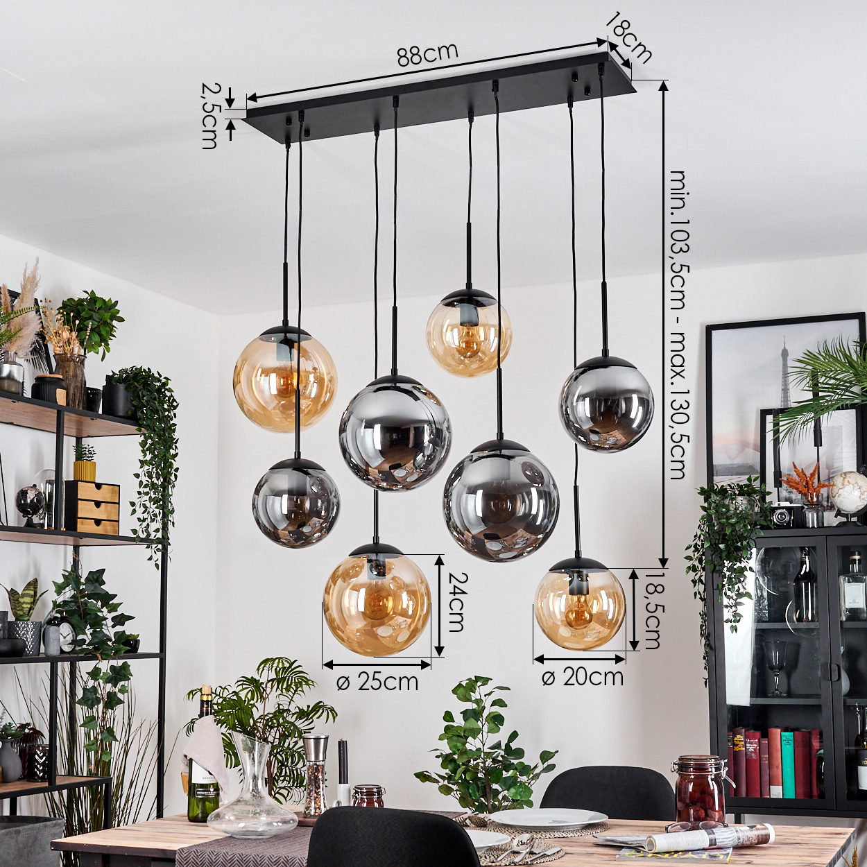 Ein modernes Esszimmer mit einem schwarzen Kronleuchter mit Glaskugeln. Verschiedene Pflanzen und Möbel sind sichtbar. Maße sind angegeben.
