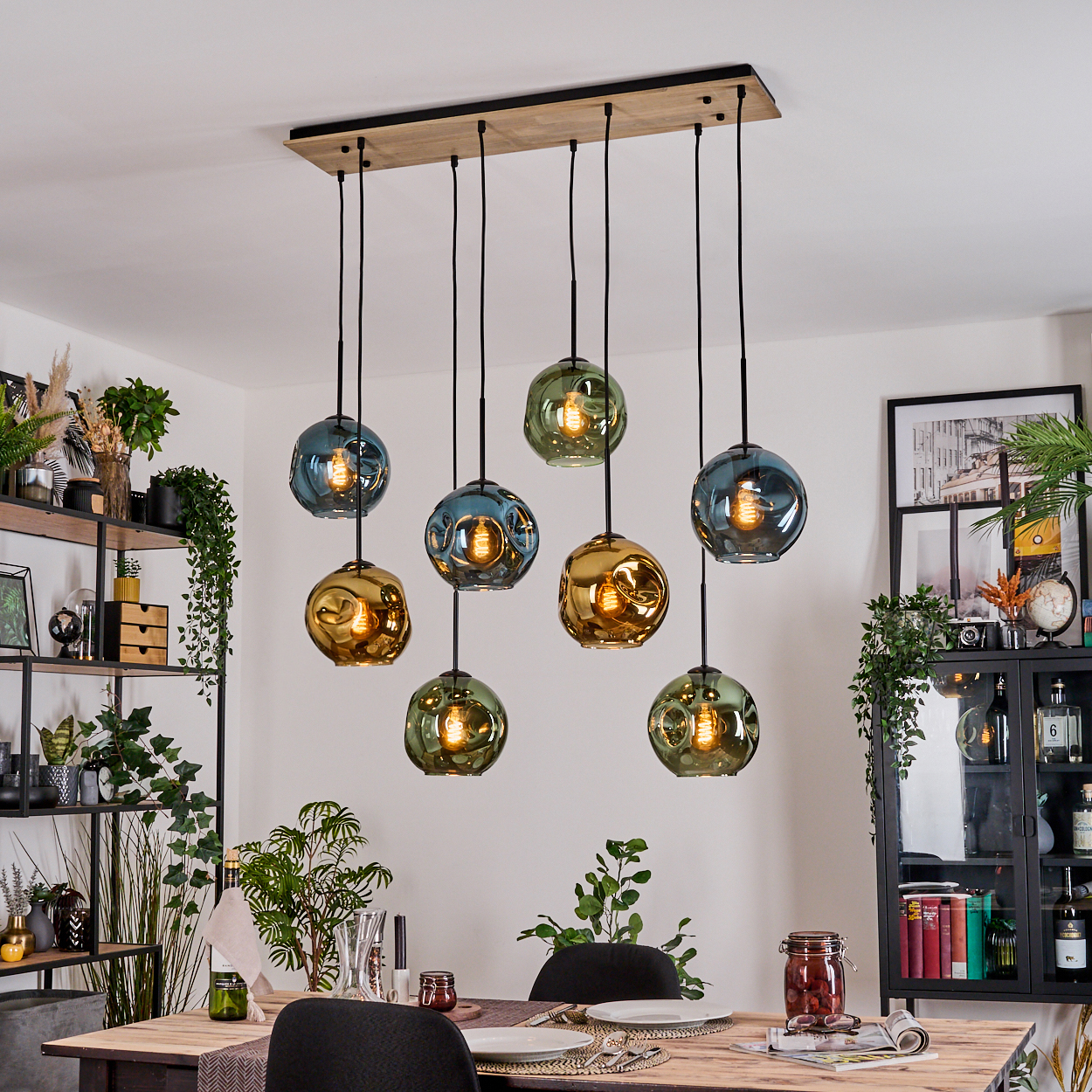 Esszimmer mit Holztisch, hängenden Blasenlichtern und schwarzem Schrank mit Pflanzen und Dekoration.