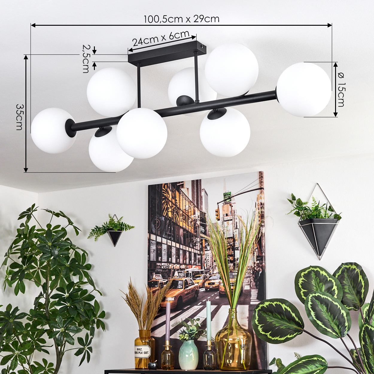 Eine moderne Deckenlampe mit weißen Kugeln wird gezeigt. Darunter ein Tisch mit Pflanzen und einem Foto von New York City.