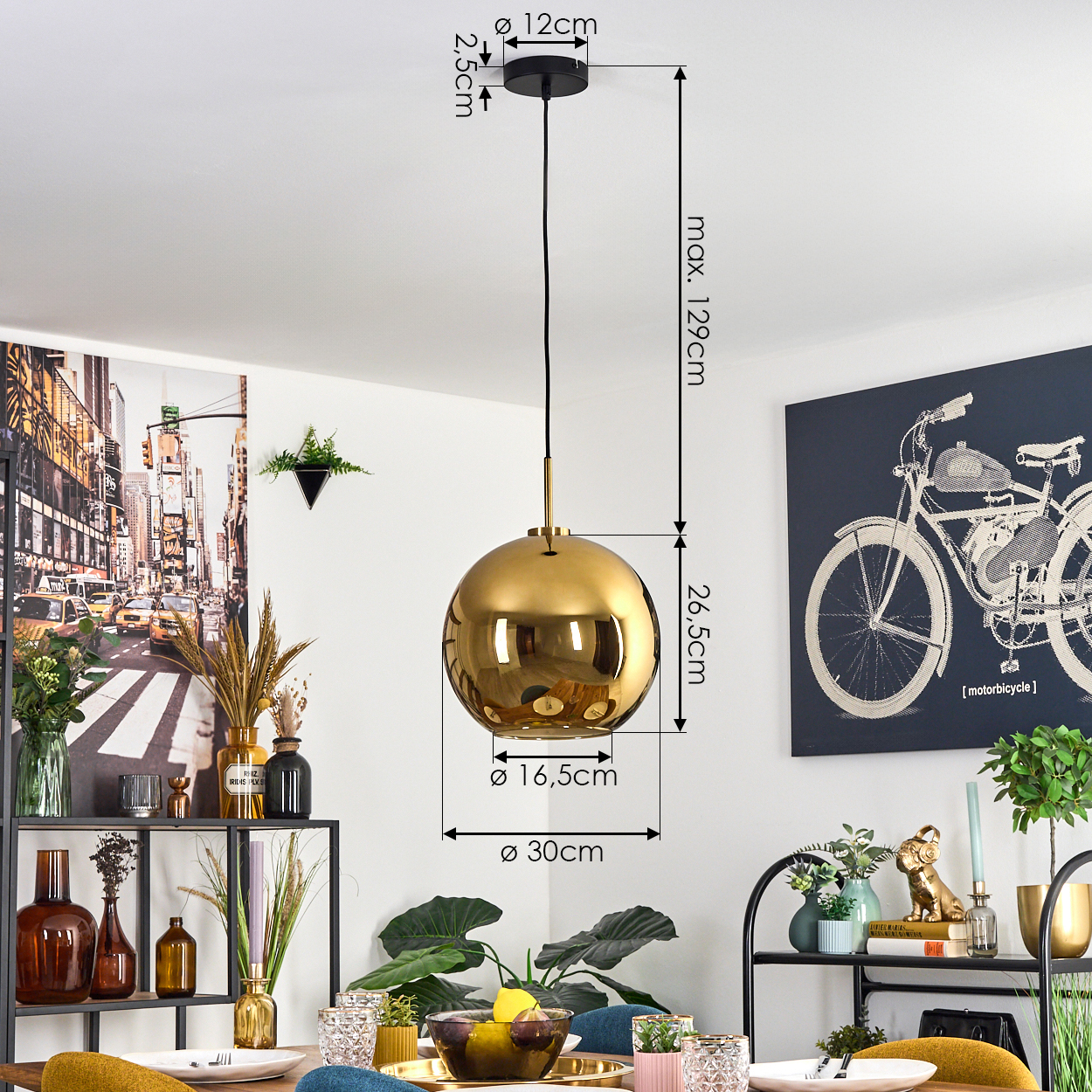 Eine goldene Pendelleuchte hängt von der Decke. Ein New York City-Bild und eine Fahrradzeichnung sind an den Wänden. Die Szene ist ein Esszimmer.