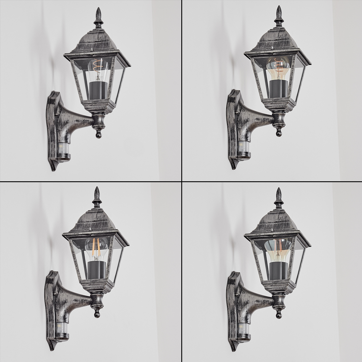 Vier graue Außenwandlampen mit Glasscheiben und einer Glühbirne, an einer weißen Wand befestigt. Jede Lampe ist leicht unterschiedlich.