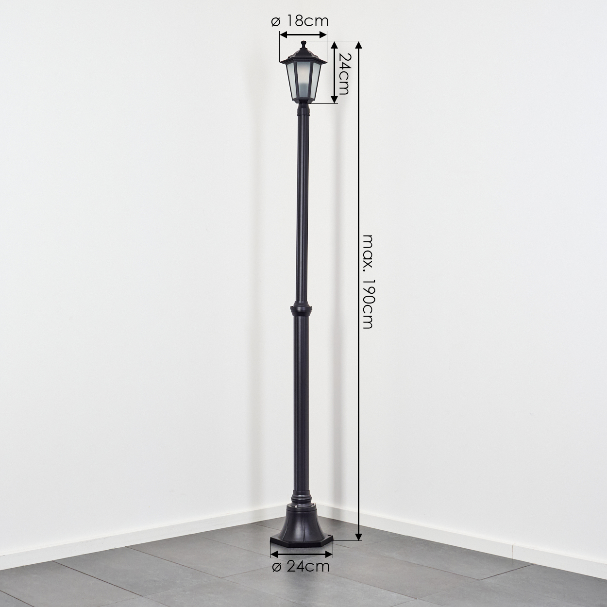 Eine schwarze Außenlaterne steht in der Ecke eines Raumes. Maße sind mit Pfeilen angegeben: Höhe 190 cm, oben 18 cm, Lampe 24 cm, Sockel 24 cm.