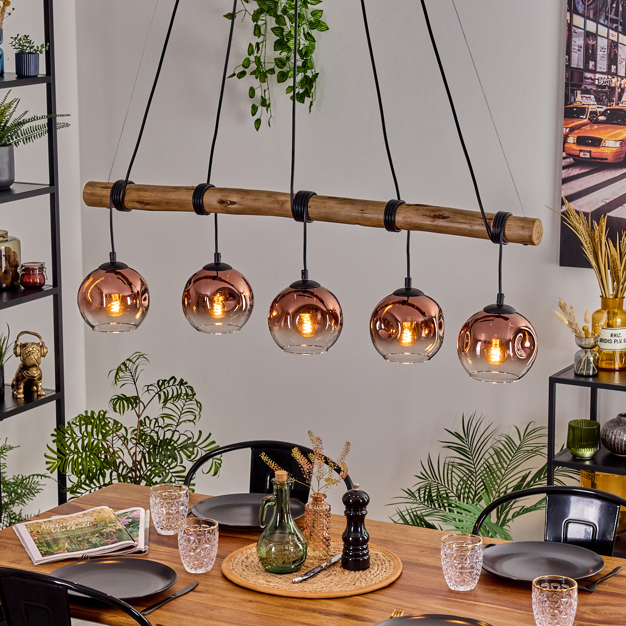 Esszimmer mit Holztisch, Hängelampen und Gedecken. Pflanzen und Dekorationen vervollständigen die Szene.