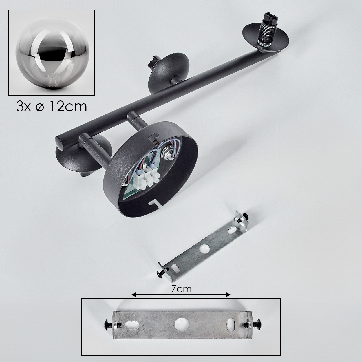Eine zerlegte schwarze Lampe mit drei Glaskugeln, einer Halterung (7cm) und einer eingebetteten elektrischen Komponente, alles auf Weiß.
