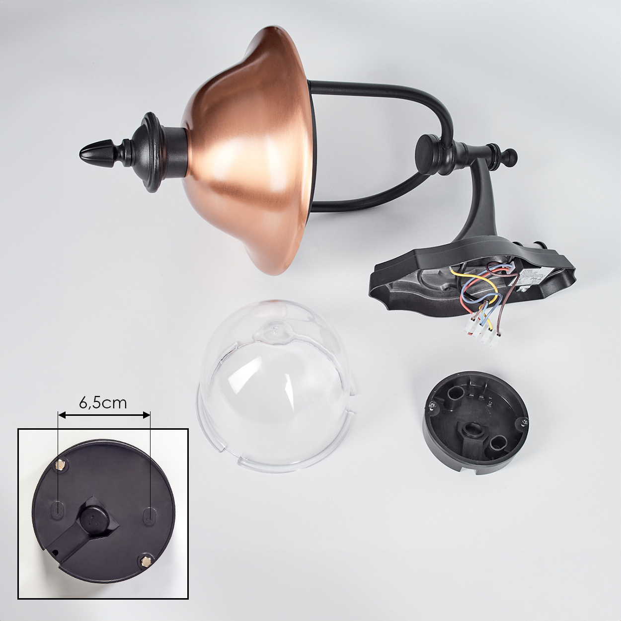 Zerlegte Außenlampe mit kupferfarbenem Schirm, schwarzem Rahmen und klarer Kunststoffabdeckung. Teile liegen auf weißem Untergrund.