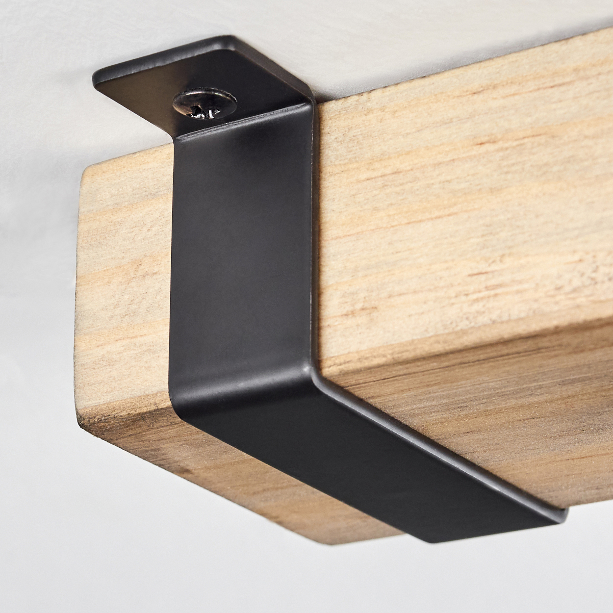 Nahaufnahme eines Holzbalkens, der von einer schwarzen Metallhalterung getragen wird, die mit einer Schraube befestigt ist, vor weißem Hintergrund.