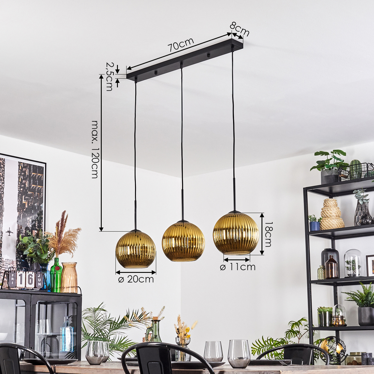 Drei goldene Pendelleuchten hängen über einem Esstisch mit Gläsern. Rechts ein schwarzes Regal mit Pflanzen. Abmessungen sind beschriftet.