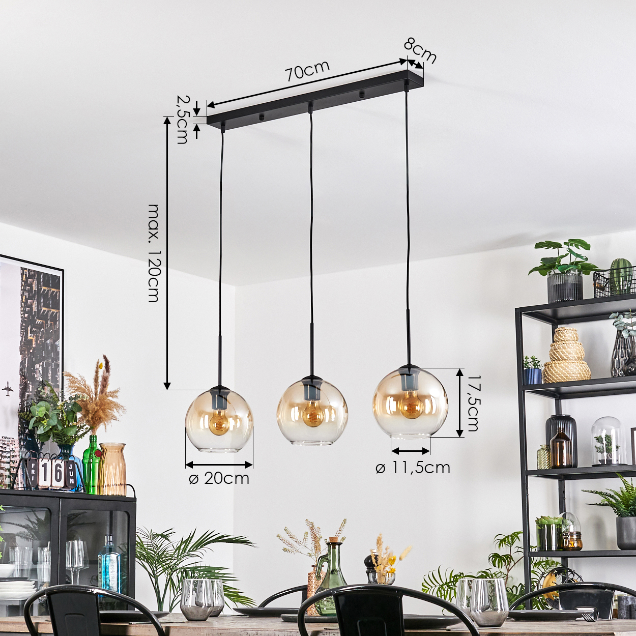 Drei Pendelleuchten mit bernsteinfarbenen Glasschirmen hängen über einem Tisch. Abmessungen sind angegeben. Hintergrund mit Regalen, Pflanzen und Dekoration.