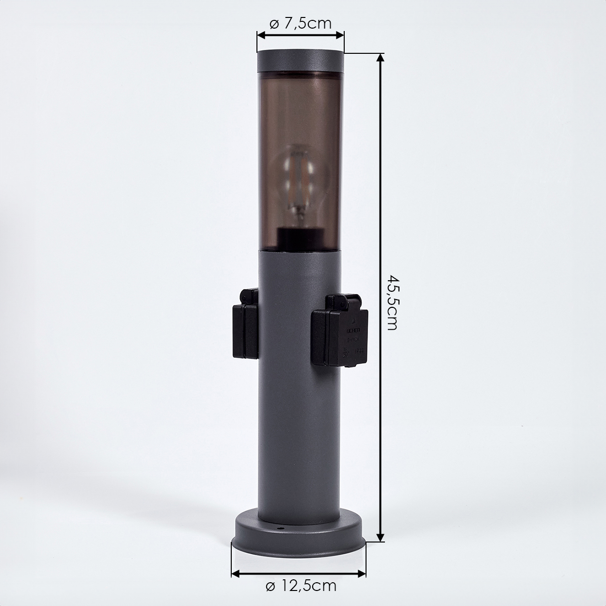 Eine graue Außenlampe mit zylindrischem Design. Sie hat einen dunklen Deckel, eine Glühbirne und zwei schwarze Steckdosen. Abmessungen sind enthalten.
