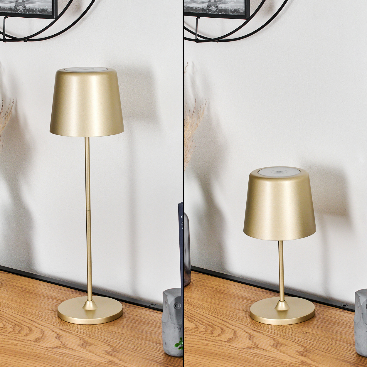 Zwei goldene Lampen auf einem Holztisch. Der Hintergrund umfasst eine weiße Wand und ein schwarz gerahmtes Bild. Dekorative Gegenstände sind ebenfalls sichtbar.