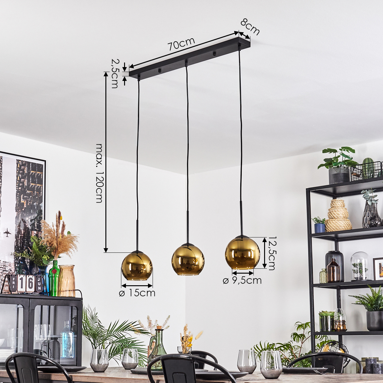 Ein modernes Esszimmer mit einem schwarzen Metallkronleuchter mit drei goldenen Kugelleuchten. Ein Tisch ist mit Gläsern und Stühlen gedeckt.