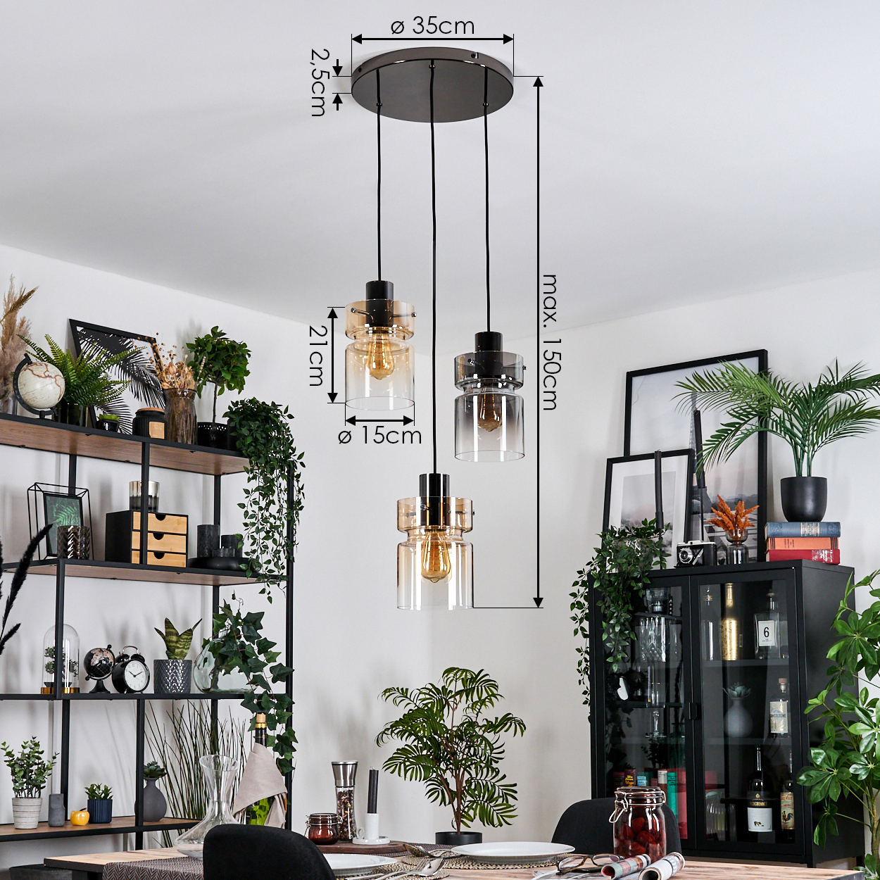 Drei Pendelleuchten mit Glasschirmen hängen von der Decke. Regale und ein Schrank sind mit Pflanzen und Dekor gefüllt.