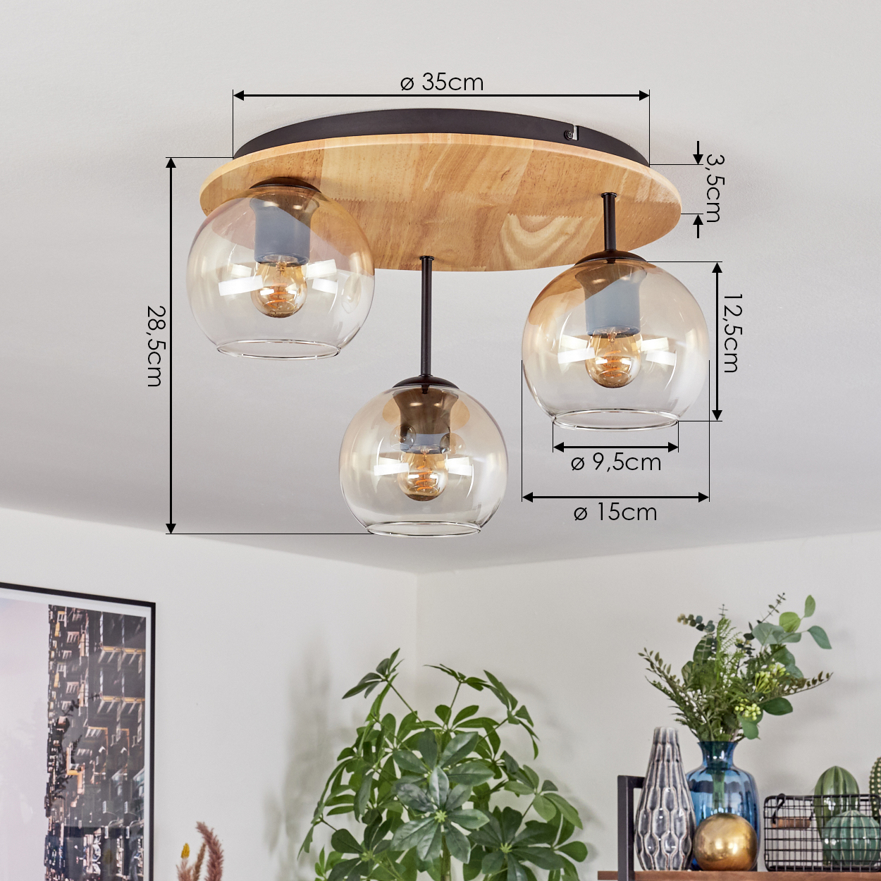 Deckenleuchte mit drei Glaskugelschirmen. Die Leuchte ist auf einem Holzsockel montiert, mit Größenangaben.