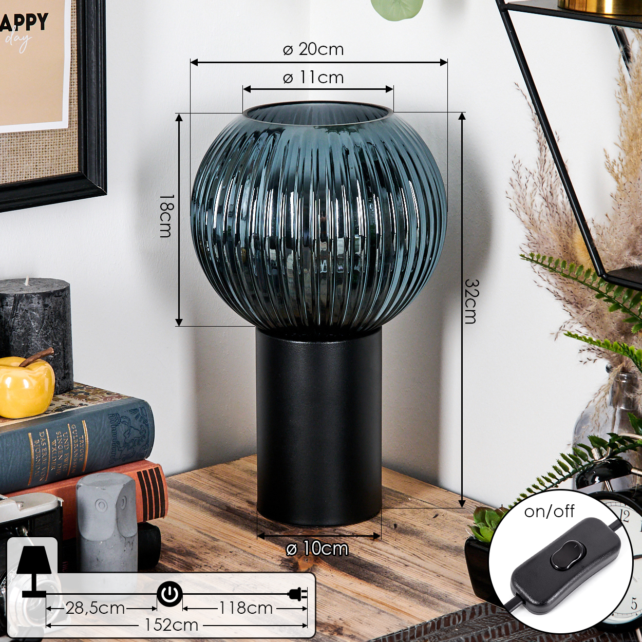 Eine dekorative Lampe mit blauem Glasschirm steht auf einem Holztisch. Weitere Objekte sind Bücher, eine Kerze und eine Uhr.