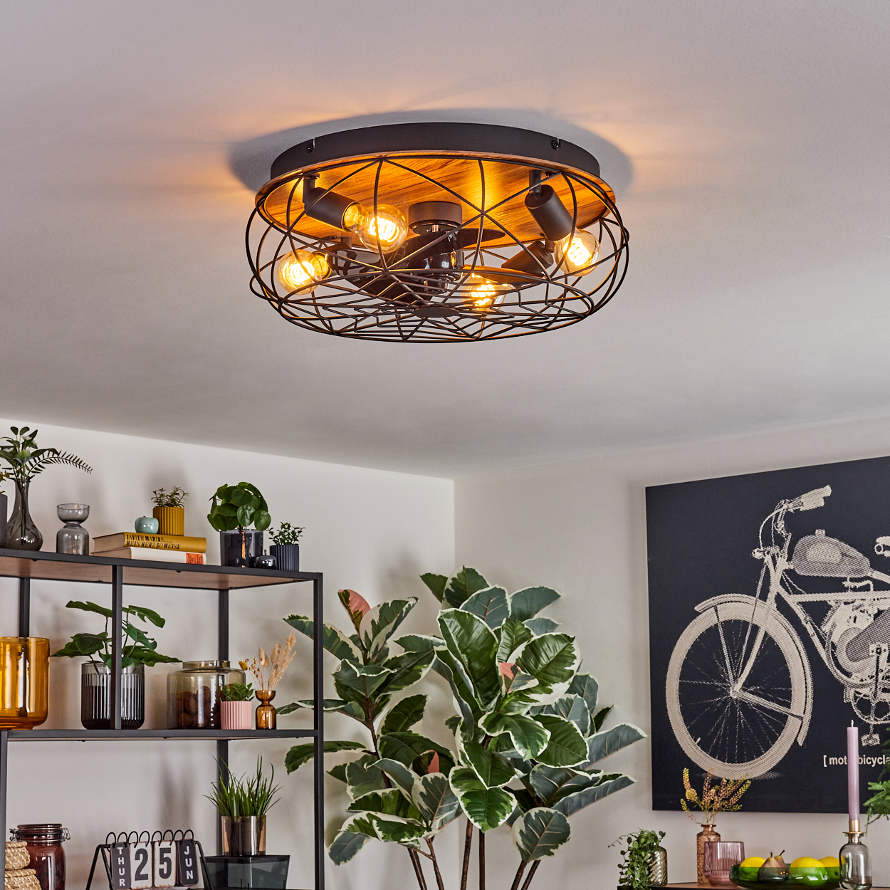 Deckenleuchte mit Edison-Glühbirnen, Pflanzen und Dekoration. Ein Motorrad-Kunstwerk auf der rechten Seite.