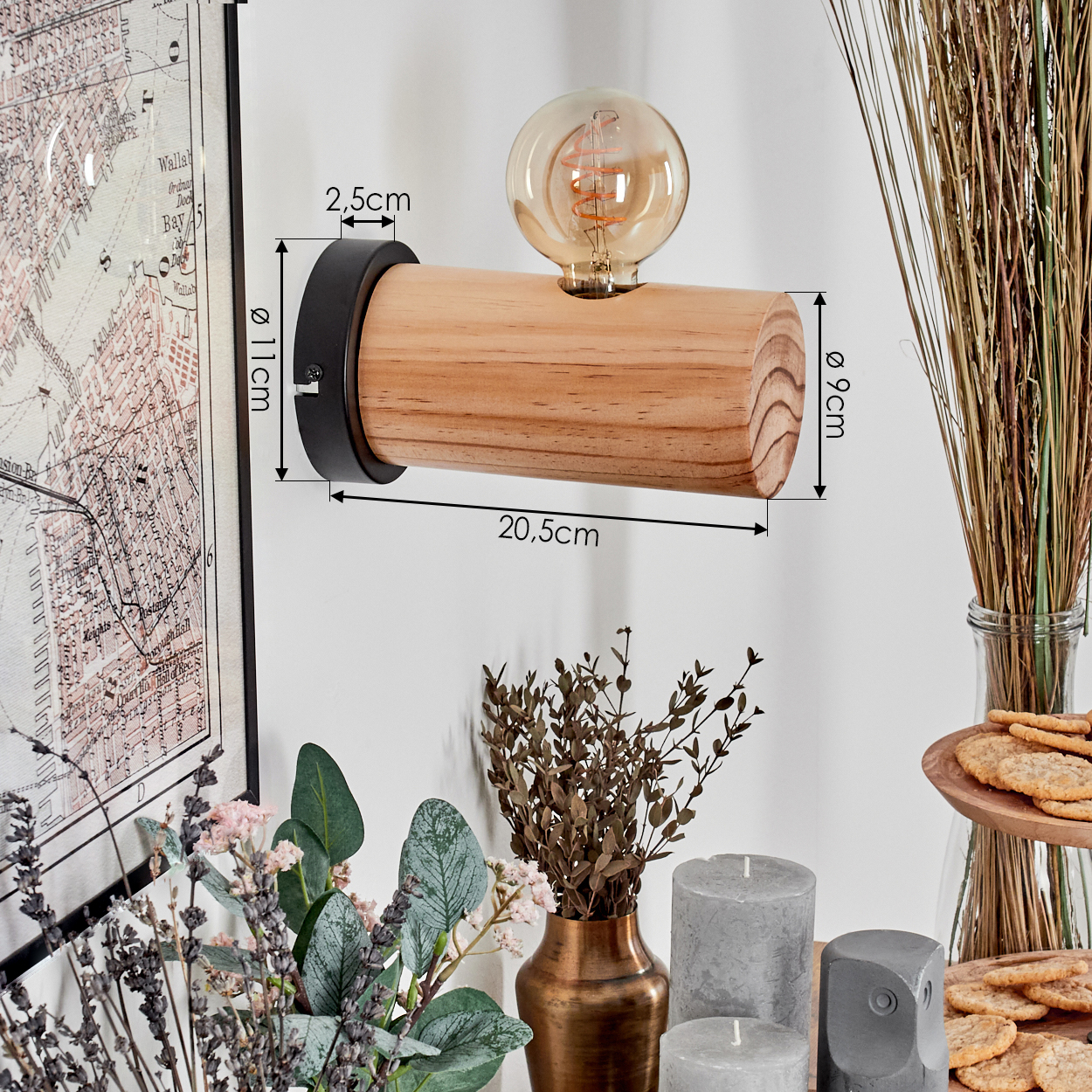 Holz-Wandleuchte mit Glühbirne. Daneben sind Blumen, Kerzen und Kekse zu sehen. Links hängt eine Karte.
