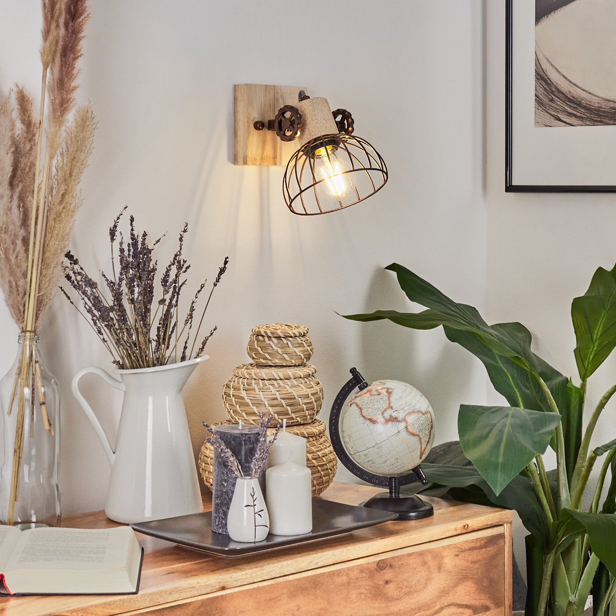 Eine rustikale Innenszene mit Wandlampe, Dekoration und Globus auf einem Holzschrank. Pflanzen und gerahmte Kunst sind sichtbar.